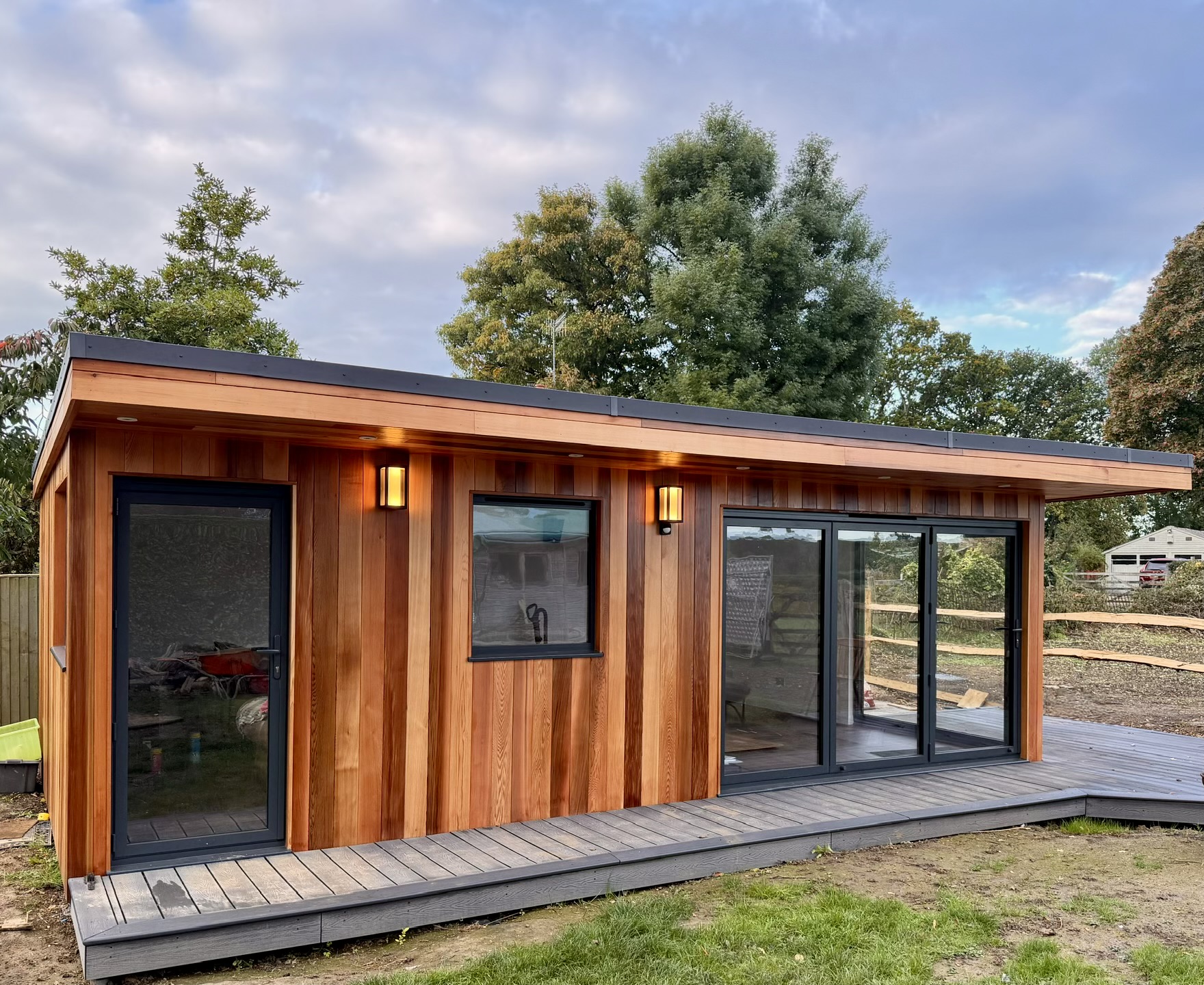 Cedar-clad SIP garden room at dusk in Surrey