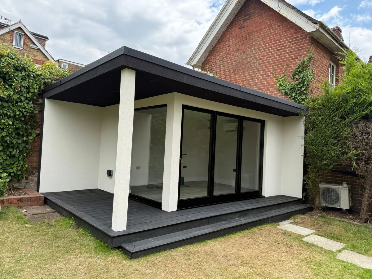 Modern rendered SIP garden room — side angle showing depth and air conditioning unit, Surrey