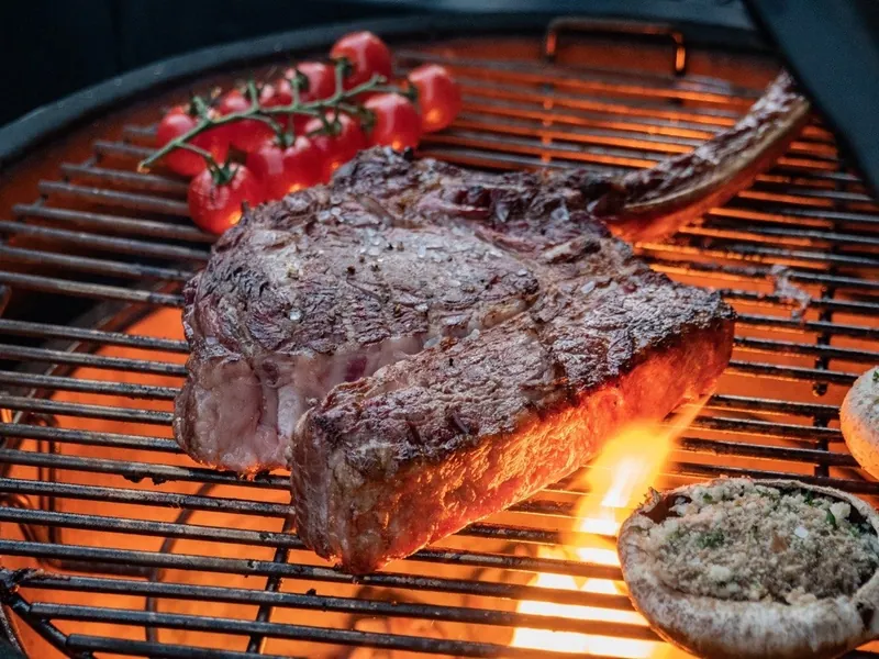 Tomahawk steak searing over the flame on a Grillo outdoor kitchen grill