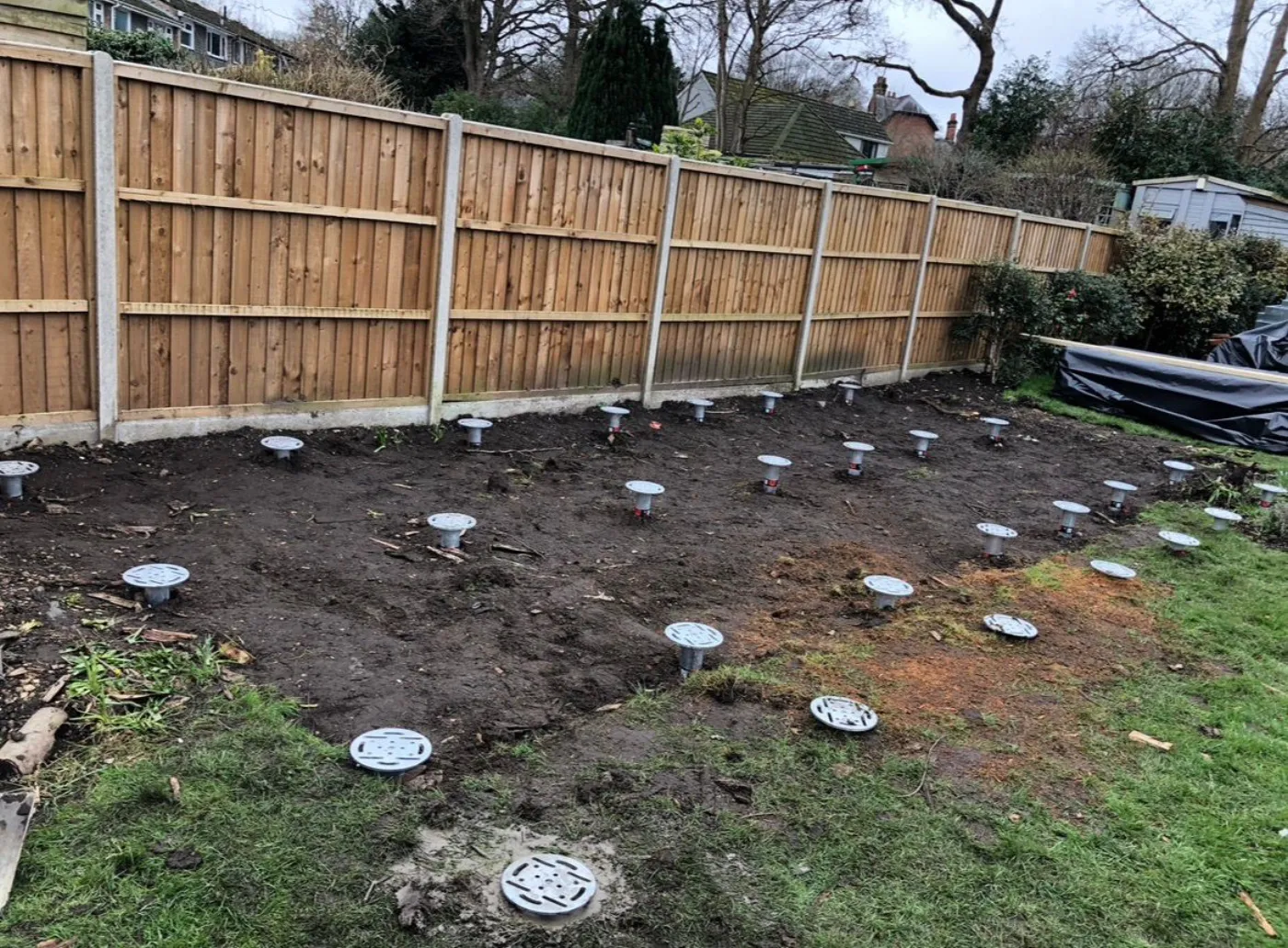 Large array of ground screws installed across a Surrey garden ready for a structural build
