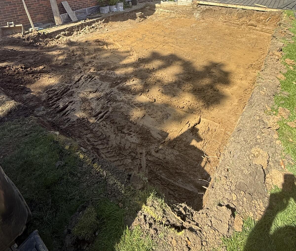 Garden room excavation showing clay soil conditions in Surrey