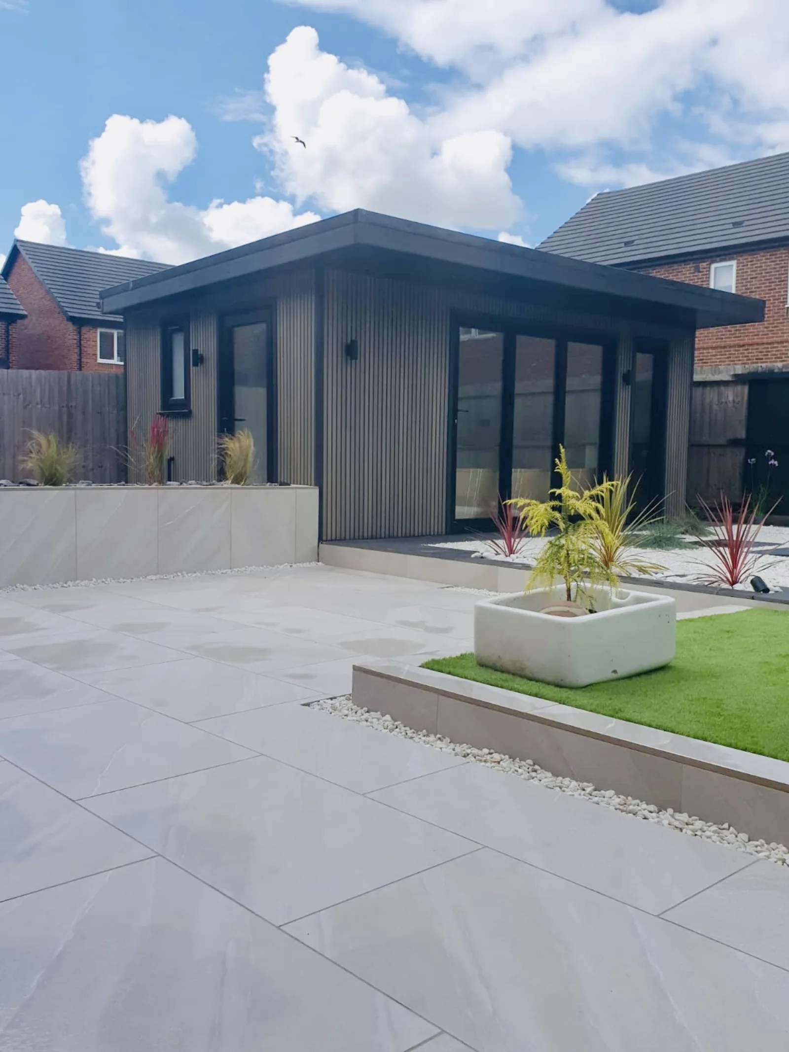 Anthracite-clad garden room with landscaped patio