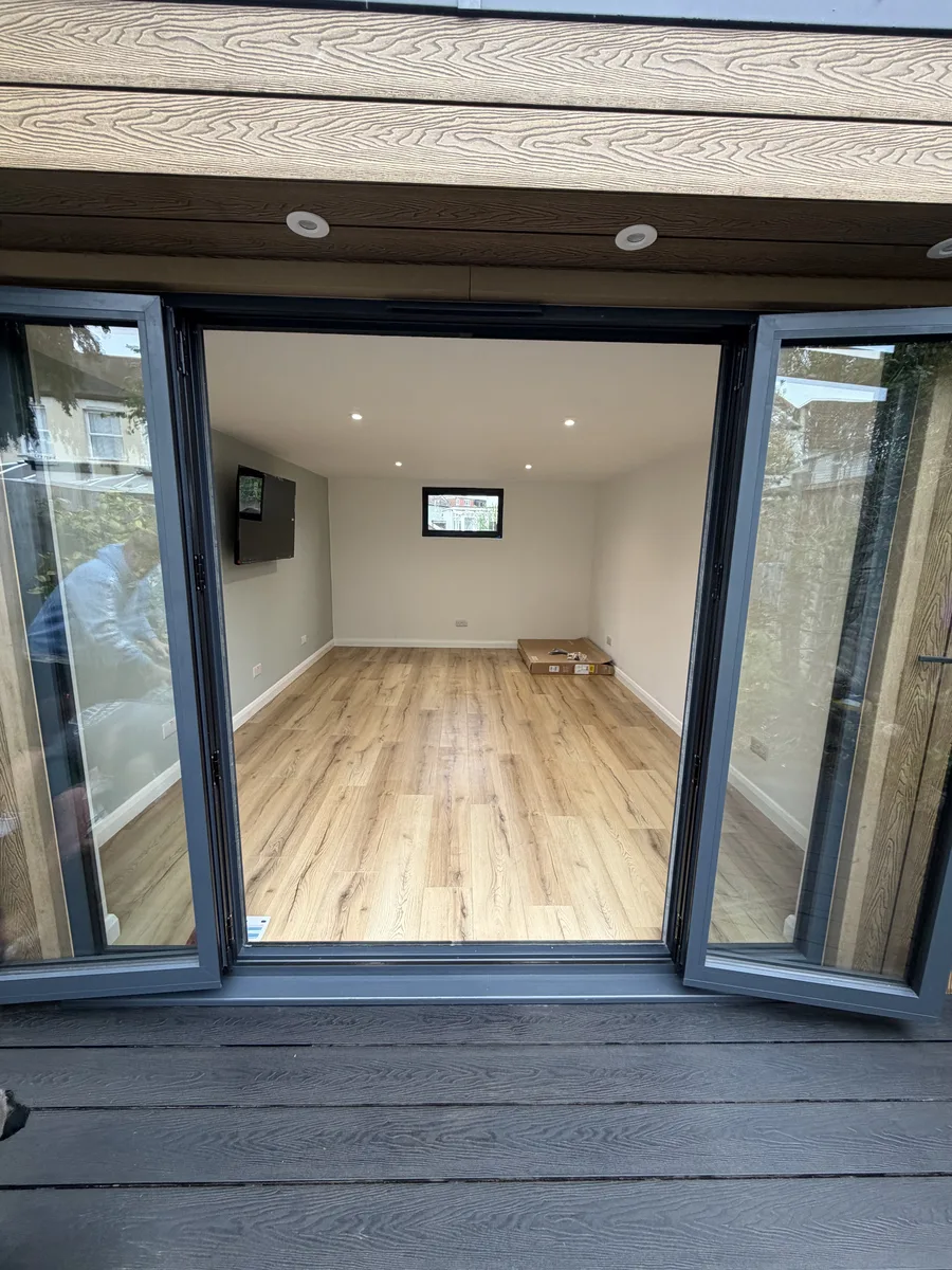 Interior of a finished Helps & Co SIP garden room in Surrey with oak-effect flooring, plastered walls and recessed lighting